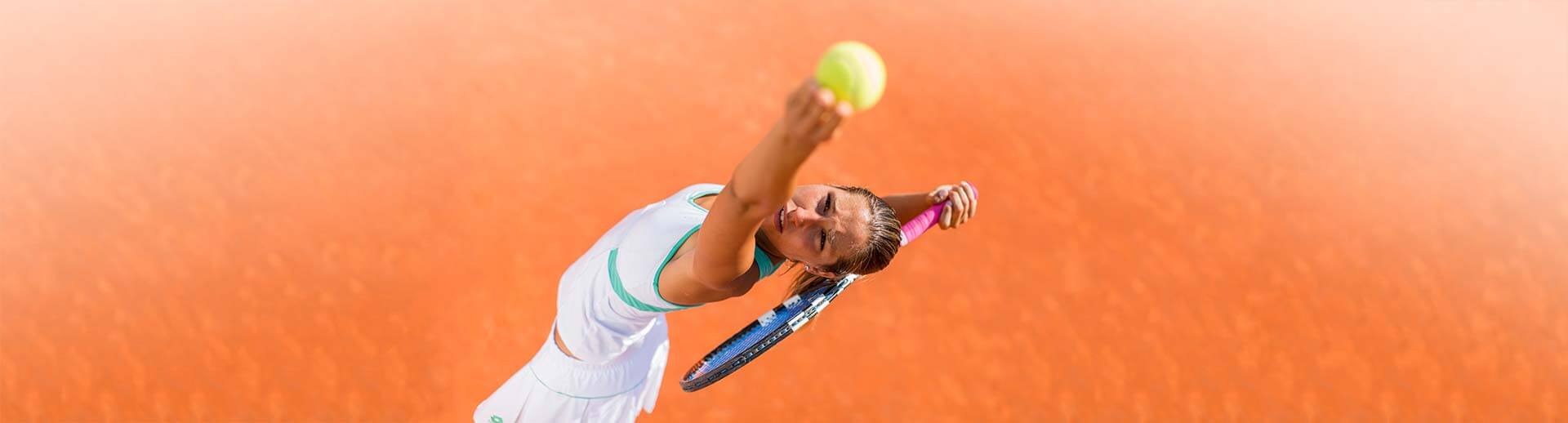 Tennisarm Operation - Frau beim Aufschlagen eines Tennisballs